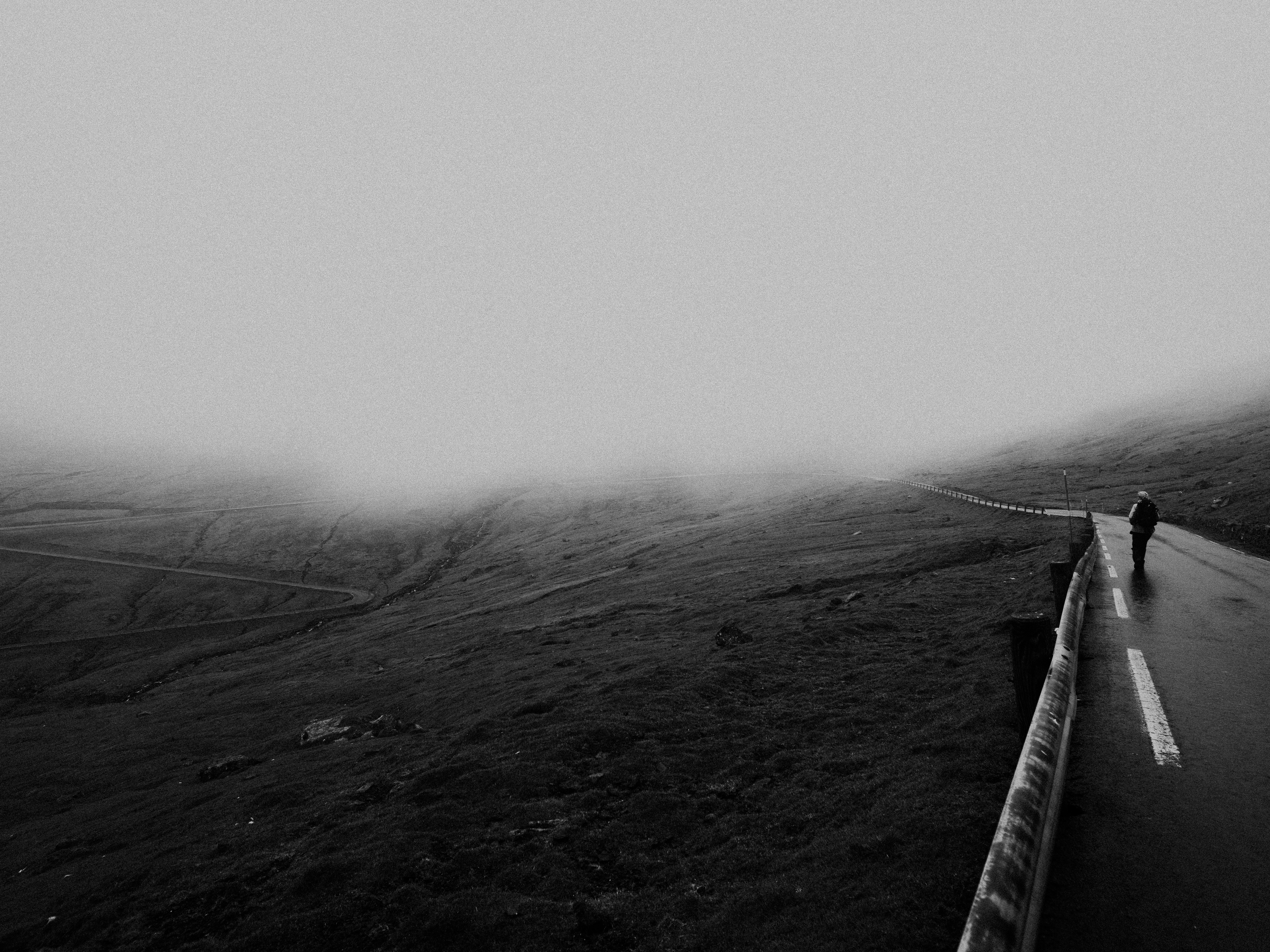 grayscale photo of a foggy mountain